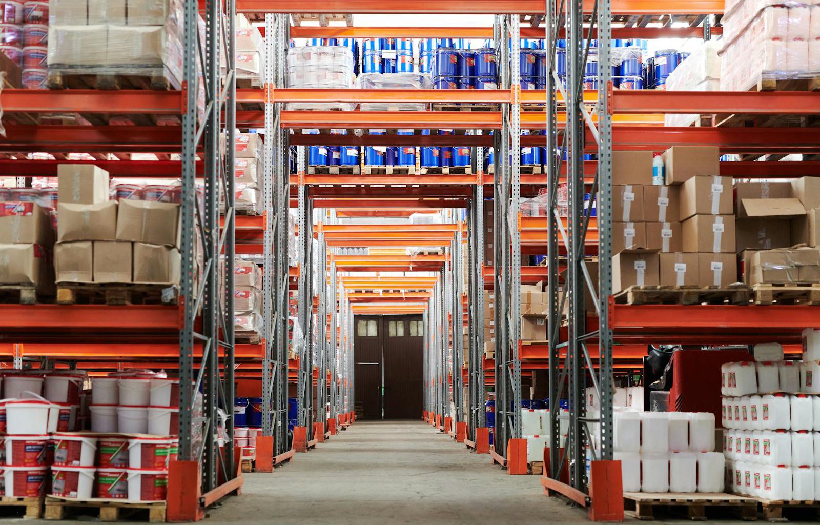 Wide angle view of a warehouse with stocked shelves and boxes.