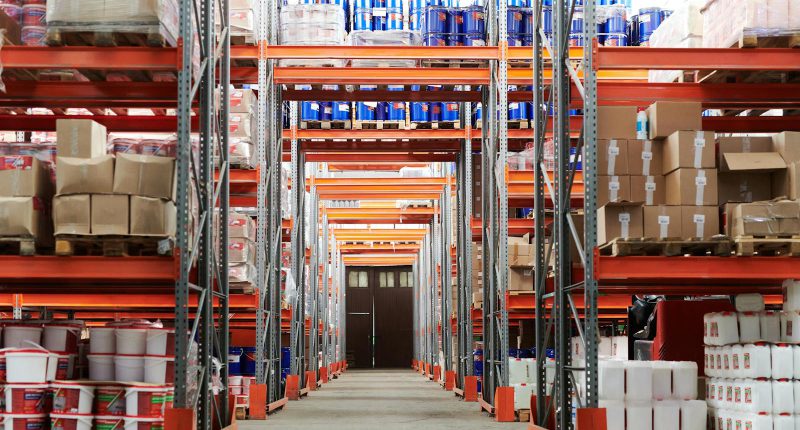 Wide angle view of a warehouse with stocked shelves and boxes.