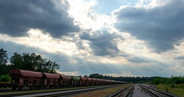 a train traveling down train tracks under a cloudy sky