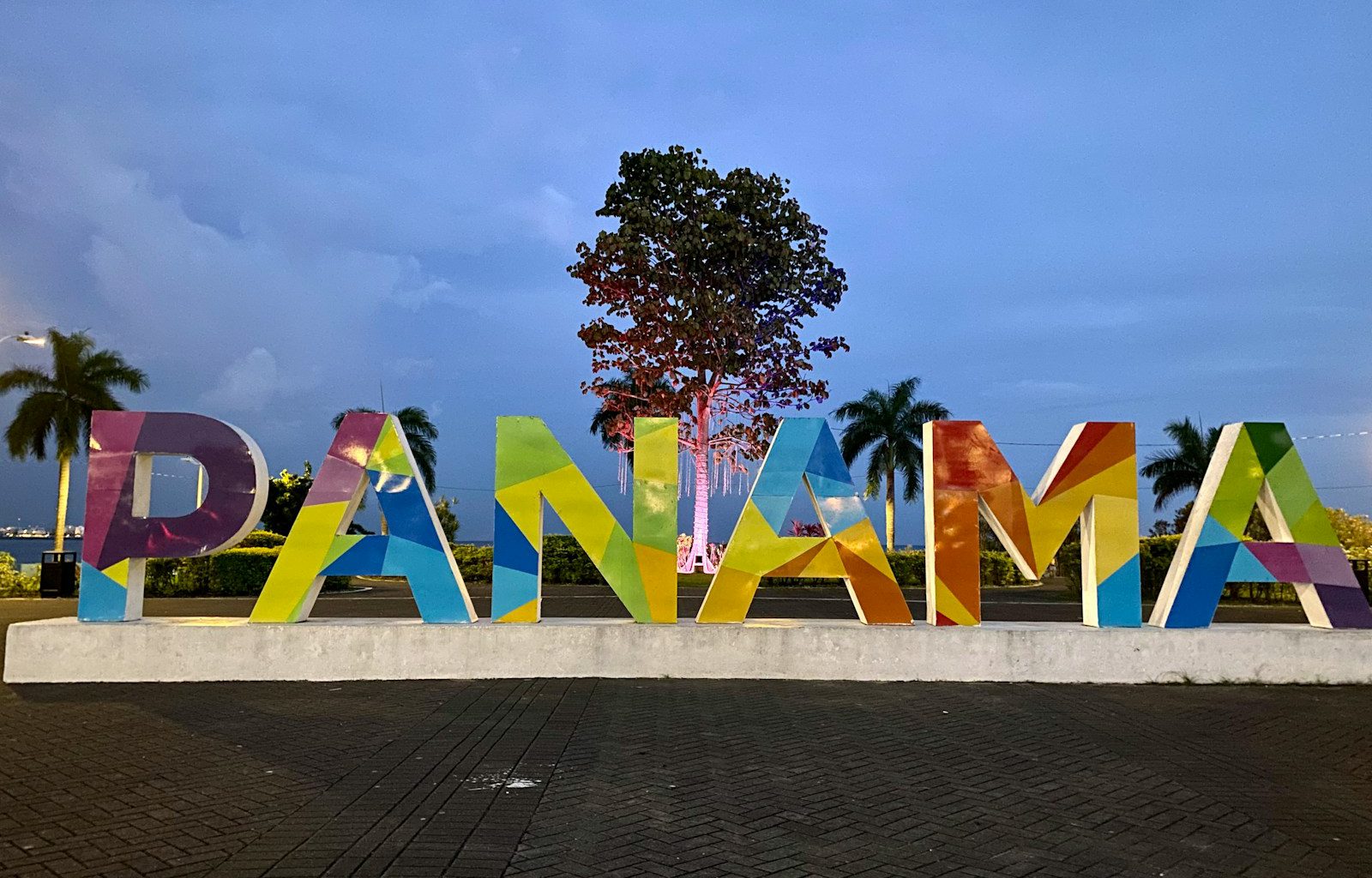 a large sign that says panama with a tree in the background