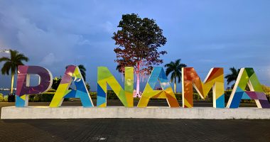 a large sign that says panama with a tree in the background