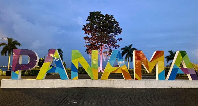 a large sign that says panama with a tree in the background